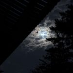 軒の下から見上げた雲に隠れる月
