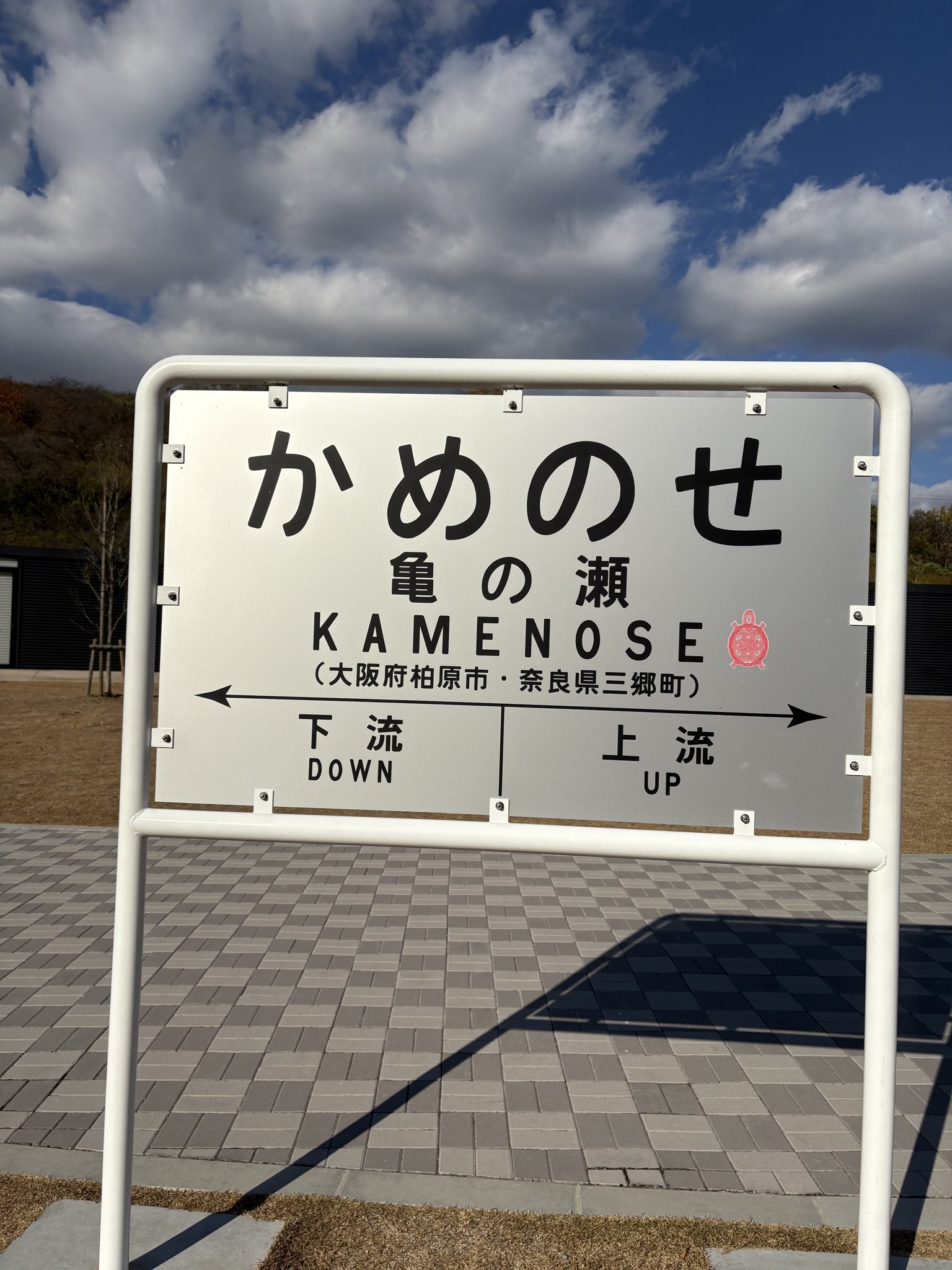 「かめのせ」の駅名標そっくりの府県境の看板