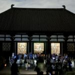 夜空を背にした唐招提寺金堂の寄棟の屋根と開かれた扉