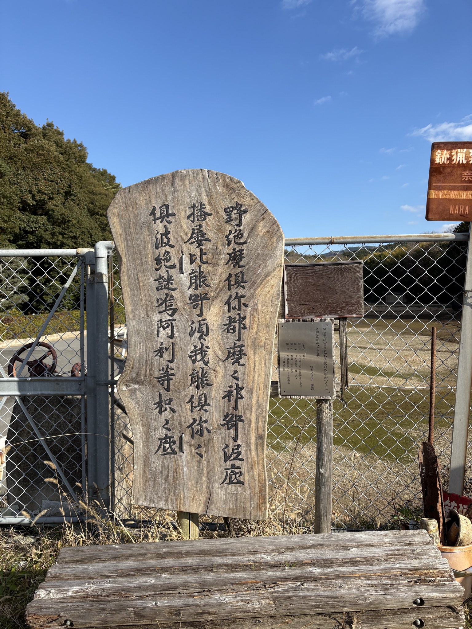 ため池のほとりの万葉仮名の歌の木札