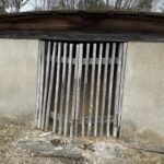 柵の向こうに開口する横穴式石室のある古墳