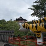 張り子の虎の向こうに立つ朝護孫子寺のお堂