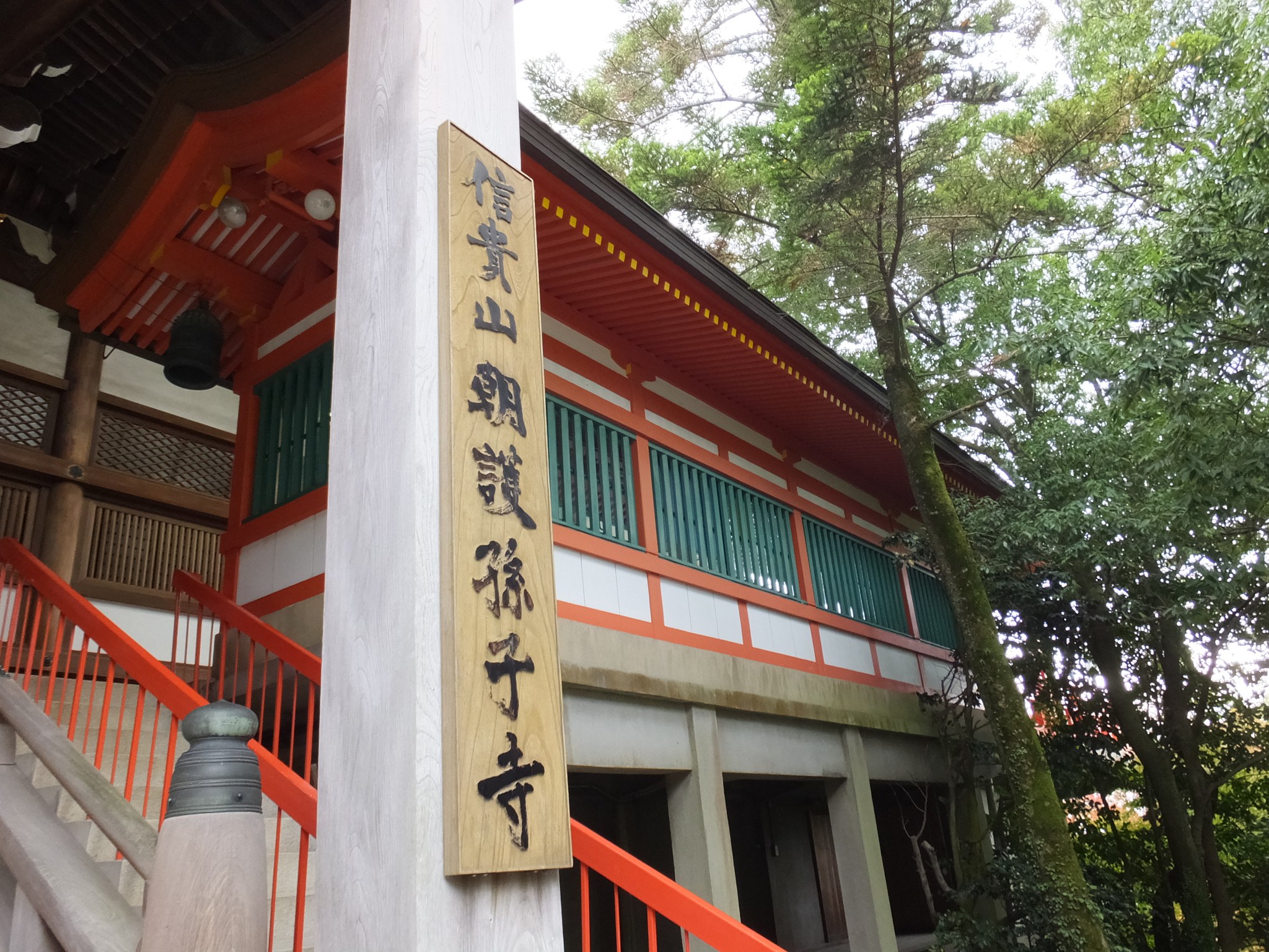 「信貴山朝護孫子寺」の扁額が掲げられた朱塗りの本堂