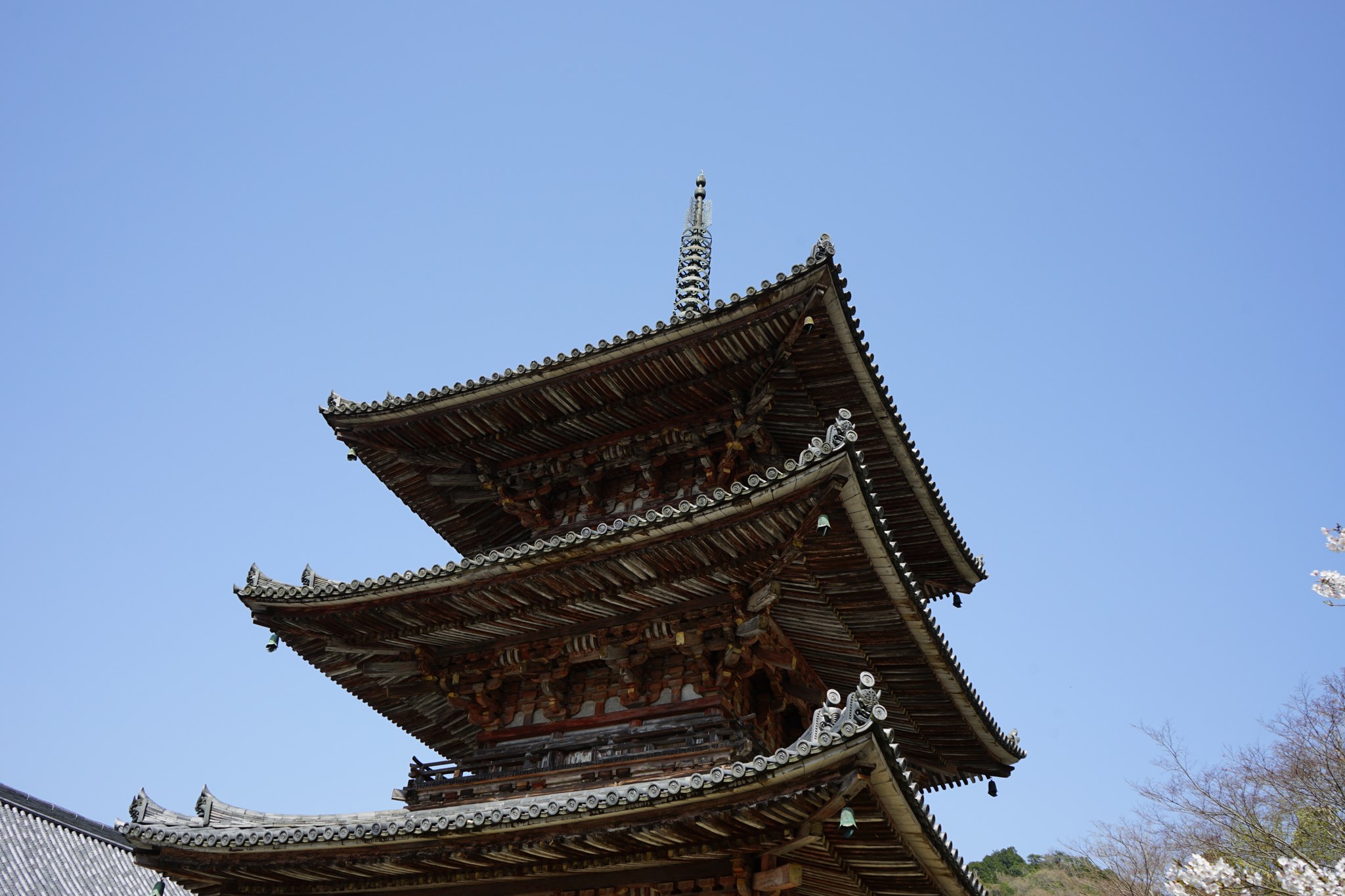 青空にそびえる壷阪寺の古色を帯びた三重塔